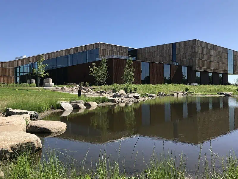 Exterior view of the Bell Museum building with a modern design, surrounded by greenery and a pond